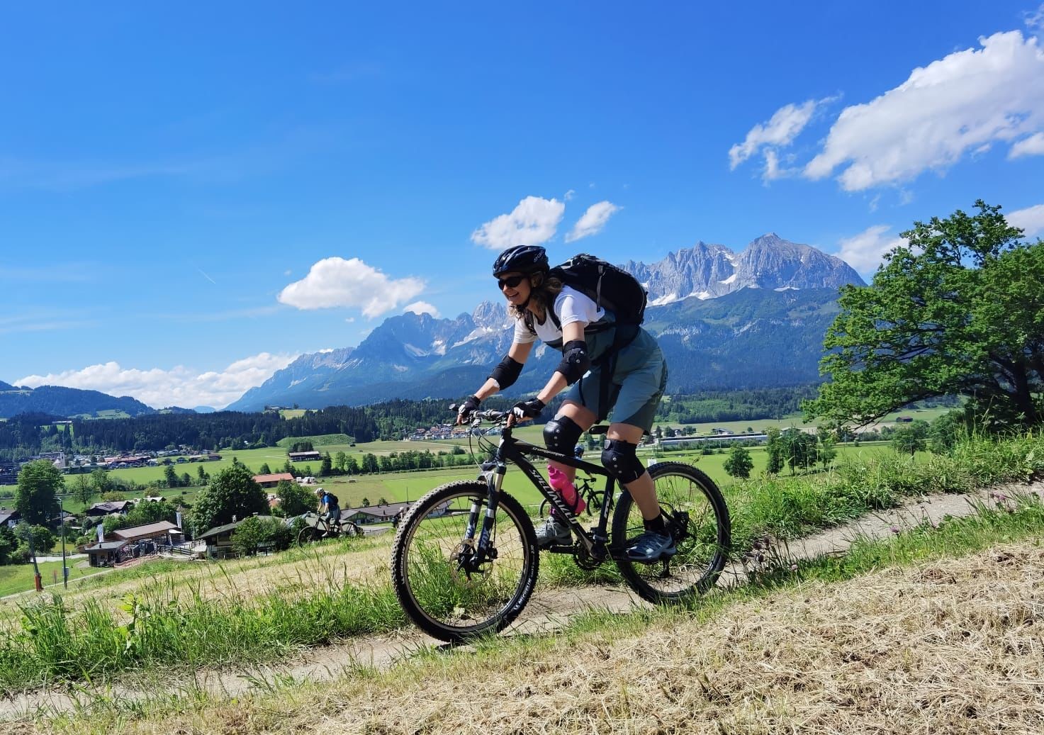 Claudia Weidner auf dem Mountainbike in alpiner Landschaft unter blauem Himmel